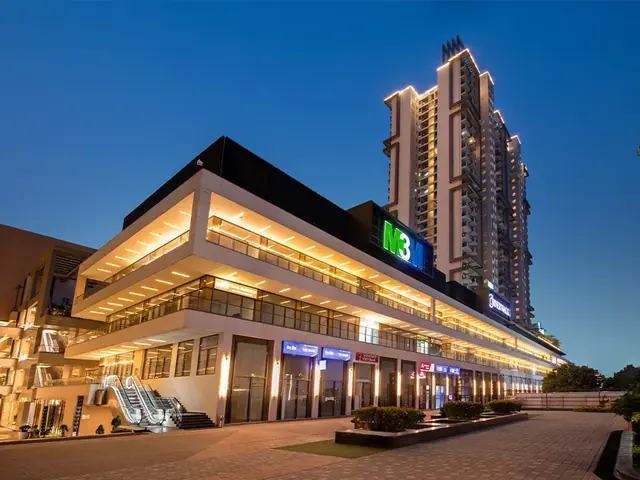 M3M Corner Walk – retail frontage lit up at dusk