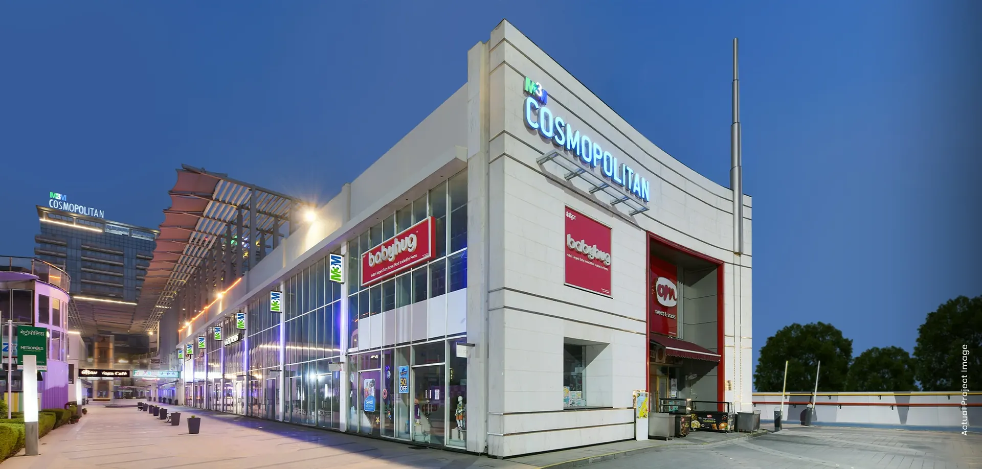 M3M Cosmopolitan – retail frontage and signage at dusk (actual photograph)