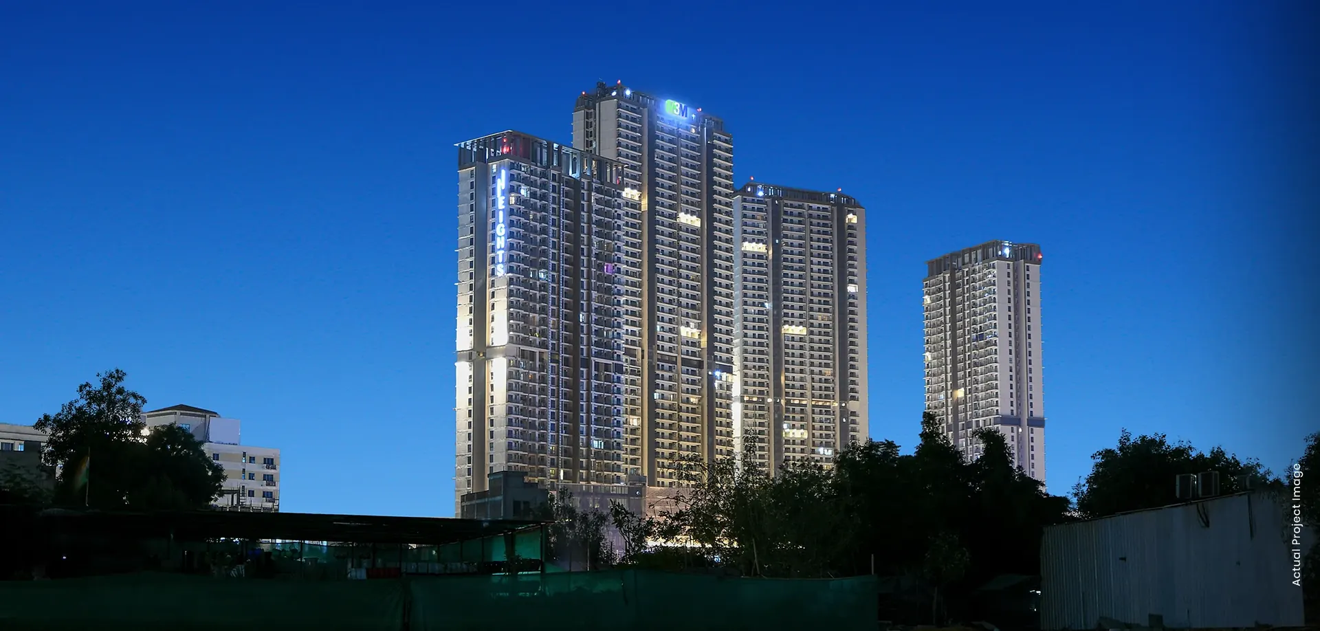M3M Heights – completed towers lit up at dusk, Sector 65 (actual photograph)