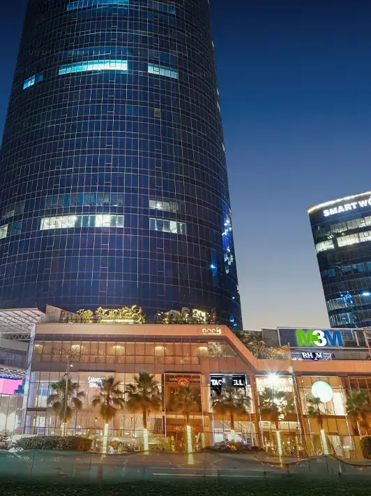 M3M IFC – both towers and the lit retail podium at night (actual photograph)
