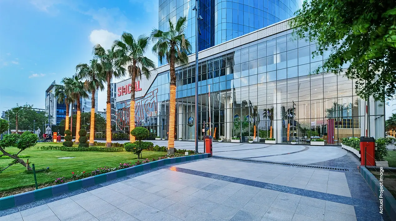 M3M IFC – landscaped retail plaza with palm-lined walkway (actual photograph)