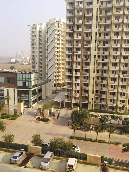 M3M Woodshire – towers and clubhouse with landscaped driveway (actual photograph)