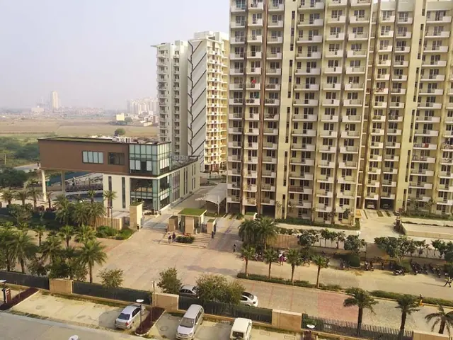 M3M Woodshire – towers and clubhouse with landscaped driveway (actual photograph)