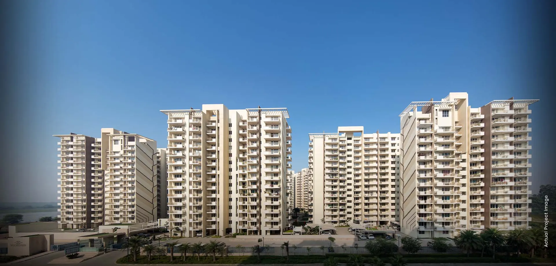 M3M Woodshire – residential towers against a clear sky (actual photograph)